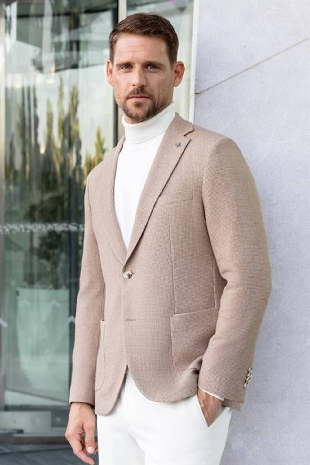 جاكيت ركبة رجال بلون بيج بتصميم نحيف ياقه أحادية، مصنوع من 64% بوليستر و34% فيسكوز و2% إلانتا، مع جيوب وسحاب مزدوج