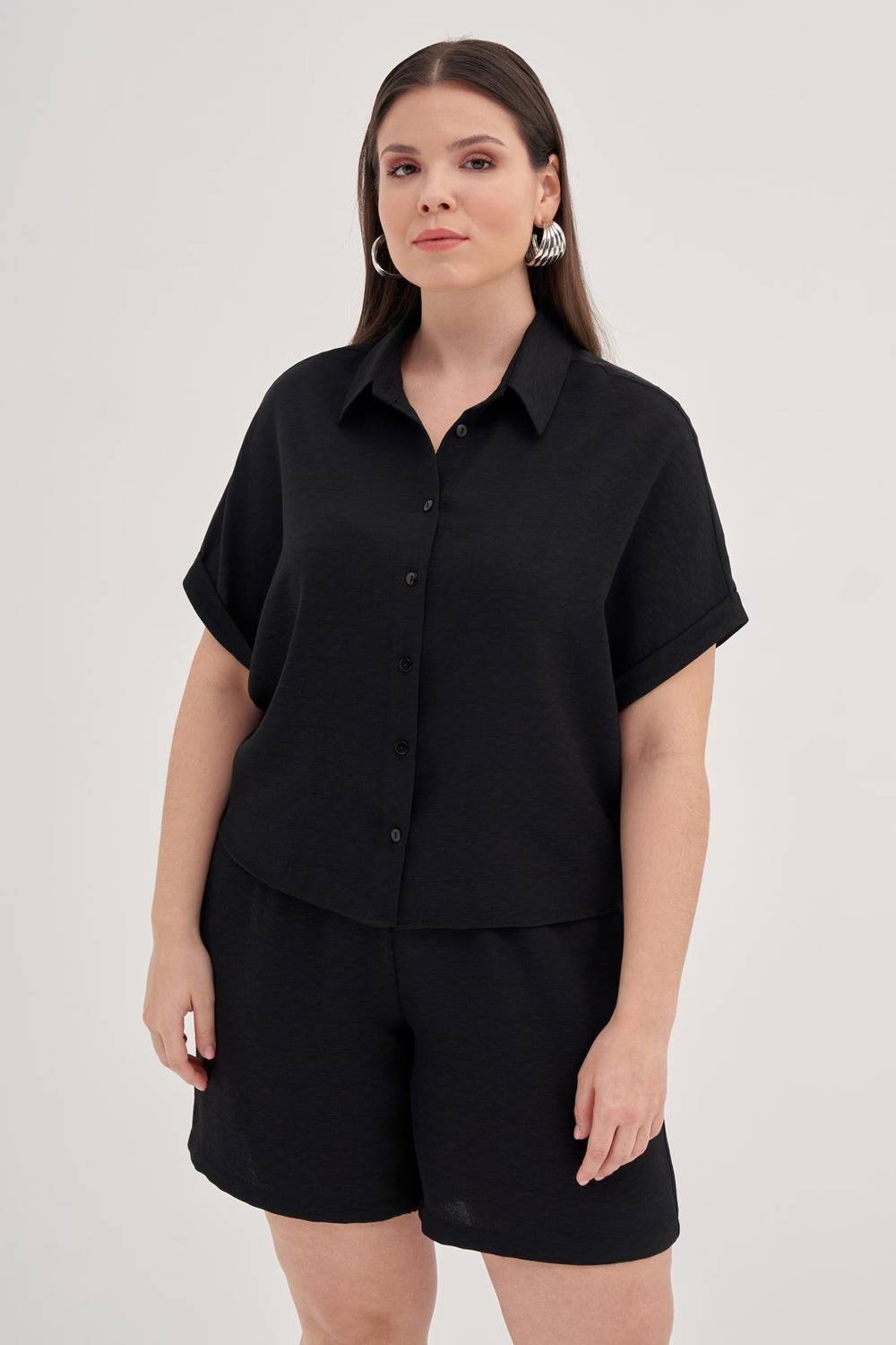 بلوزة قصيرة الأكمام بأحجام كبيرة، تصميم مريح، قماش بوليستر بنسبة 100%، لونها أسود، مثالية للإطلالات العصرية