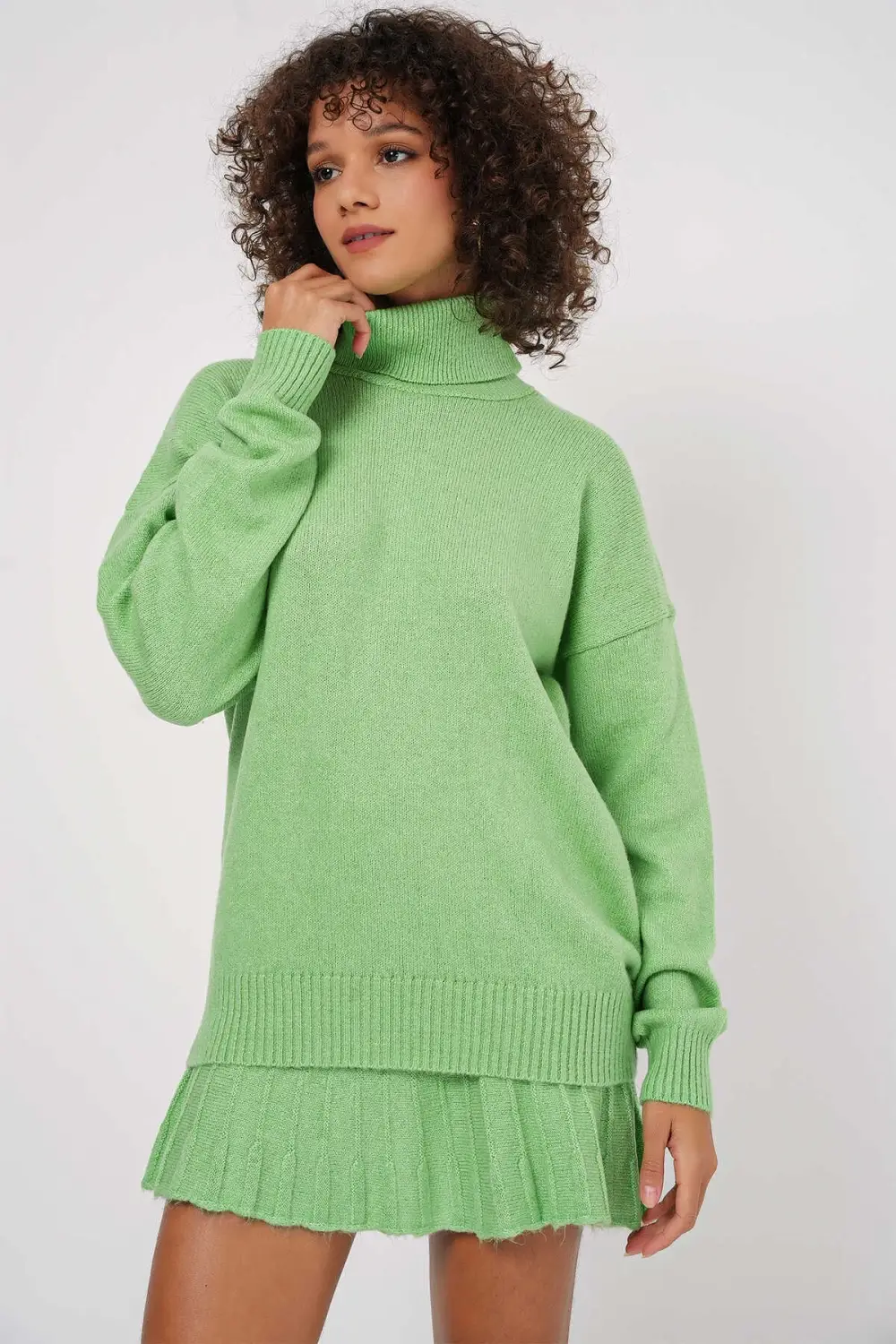 طقم نسائي من الصوف الأخضر الفستقي بياقة عالية مع تنورة من القماش المرن مريح ومناسب لجميع الفئات العمرية