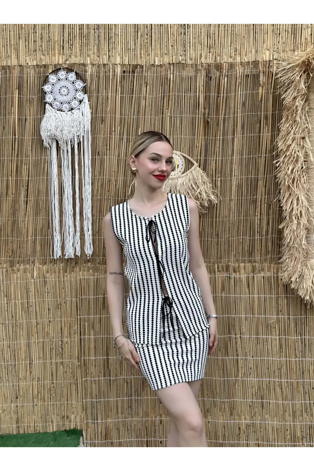 طقم تريكو بألوان الأسود والأبيض مع بلوزة مربوطة من الأمام وتنورة عصرية مناسب لمقاسات 34-40 مصنوعة من بوليستر خالي من الطي